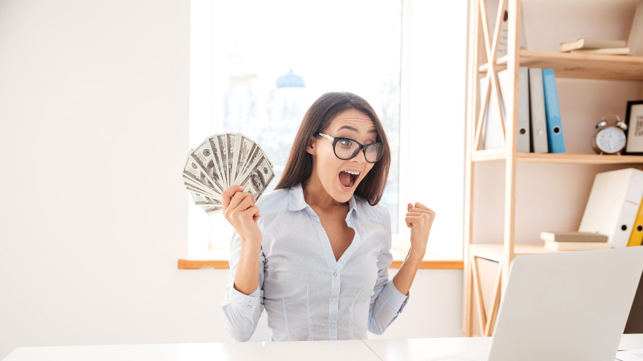 紙幣を持って喜んでる女性