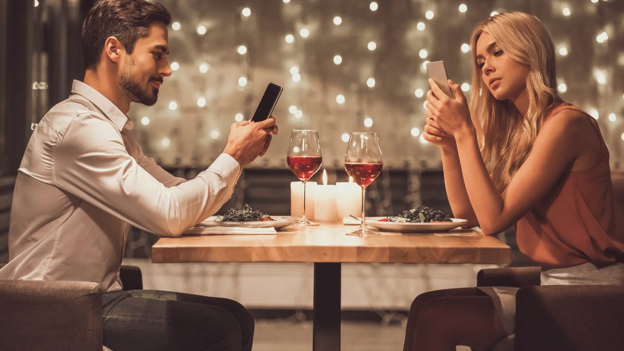 男女が向き合ってスマホを触っている