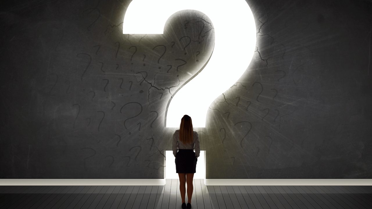 はてなマークの前に立ってる女性